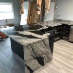 Modern kitchen island with striking black and white granite countertop.