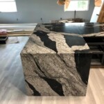 Polished black and beige marble countertop with bold, natural veining.