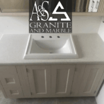 White granite countertop with an integrated sink on a vanity.