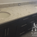 Elegant bathroom countertop with marble finish and dark cabinets.