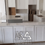 Modern kitchen with white cabinetry and stainless steel appliances.