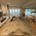 A spacious kitchen with a large island featuring a unique marble countertop.