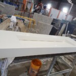White wooden panels drying in a workshop.