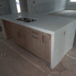Modern kitchen island with built-in sink and wooden cabinets.