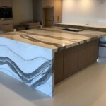 Modern kitchen island with marble countertop and wooden base.