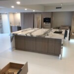 Modern kitchen with marble countertops and wooden cabinetry.