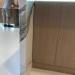Person standing near a kitchen cabinet and counter.