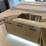 Modern kitchen island with built-in sink and under-cabinet lighting.