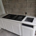 Modern kitchen countertop with built-in cooktop and induction stove.