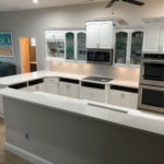 Modern white kitchen with spacious countertops and built-in appliances.
