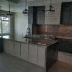 Modern kitchen with a large island and industrial pendant lights.