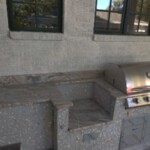 Outdoor kitchen corner with a built-in grill and countertop space.