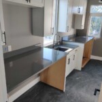 Modern kitchen cabinets with open doors and a sleek countertop.