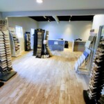 Modern flooring showroom with wood samples and bright lighting.