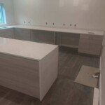 Newly installed modern kitchen cabinets and island with a sleek design.