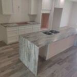 Modern kitchen with a marble island and sleek cabinetry.