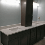 Modern bathroom vanity with dual sinks and dark cabinetry.