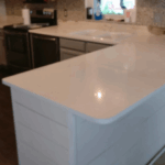 Modern kitchen island with a sleek white countertop and built-in sink.