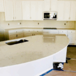 Modern kitchen with a large curved white countertop and built-in sink.